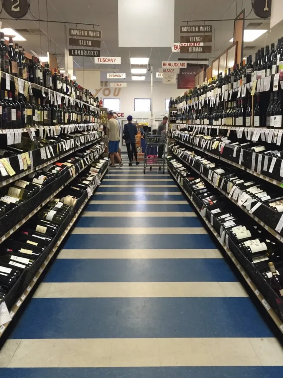 Imported wines arranged by region in an aisle at Circle Liquor Store